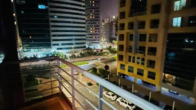 a view from a balcony of a city at night at Divine Partition Room Barsha Heights Tecom in Dubai
