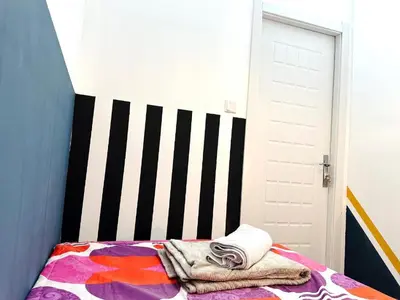 a bedroom with a bed with a striped wall at Magnificent Partition Room in Barsha Heights Tecom in Dubai
