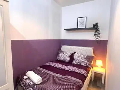 a small bedroom with a purple and white wall at Excellent Partition Room In Barsha Heights Tecom in Dubai