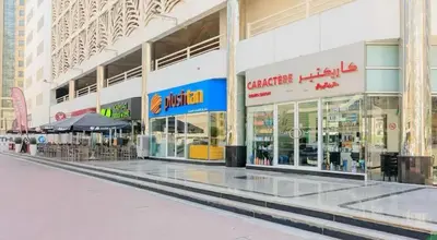 a shopping mall with tables and chairs in front of it at Incredible Partition Room In Barsha Heights Tecom in Dubai