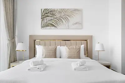 a bedroom with a white bed with two towels on it at VayK - Large 1BR Near Hospital and Mall in Dubai