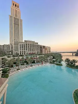 a large swimming pool with lounge chairs and buildings at VayK - Classy 1BR Near the Lagoon in Creek Harbour in Dubai