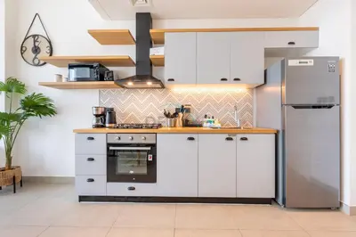 a kitchen with white cabinets and a stove at Furnished 1BR Near Dubai Hills Park, Close to the Iconic Dubai Hills Mall, Only 15 Minutes from Burj Khalifa, Collective 20 Tower B, Dubai Hills by Deluxe Holiday Homes in Dubai