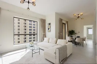 a white living room with a white couch and a table at Upgraded 1BHK with Stunning Marina Views in Dubai