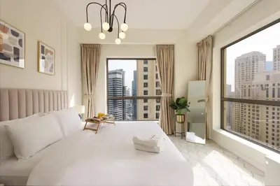 a bedroom with a large white bed with a large window at Upgraded 1BHK with Stunning Marina Views in Dubai