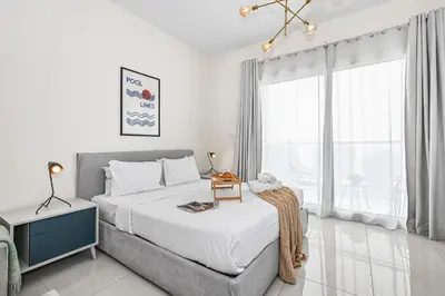 a bedroom with a bed and a large window at Enjoy Modern Comforts with Views of Burj Al Aráb and Nearby Attractions in Dubai