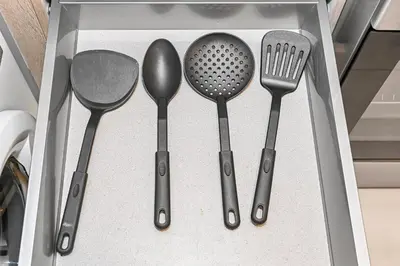 a drawer filled with utensils in a drawer at Enjoy Modern Comforts with Views of Burj Al Aráb and Nearby Attractions in Dubai