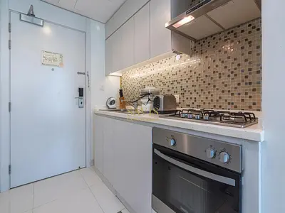 a small kitchen with a stove and a sink at Savis Homes - The Voleo - Bright and elegant studio - Business Bay in Dubai in Dubai