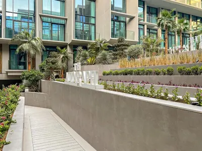 a building with a garden in front of it at Stylish studio Near Downtown Dubai with Pool & Gym Access in Dubai
