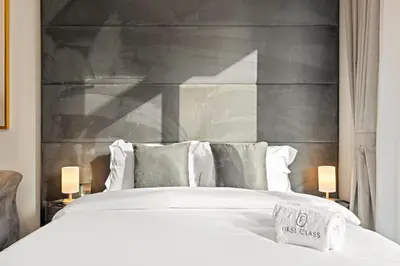 a bedroom with a white bed with a large headboard at Stylish studio Near Downtown Dubai with Pool & Gym Access in Dubai