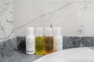 four bottles of essential oils sitting on a bathroom sink at FIRST CLASS 1BR Elegant Comfort Awaits in Dubai