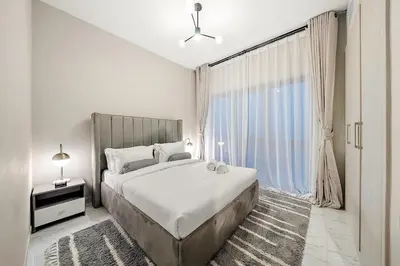 a bedroom with a large bed and a large window at FIRST CLASS 1BR Elegant Comfort Awaits in Dubai