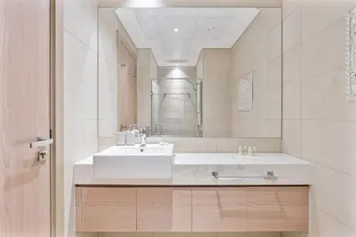 a bathroom with a white sink and a mirror at Studio Apartment near Al Quoz Pond Park in Dubai