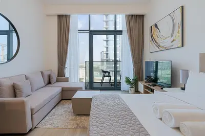 a living room with a couch and a tv at Studio Apartment near Al Quoz Pond Park in Dubai