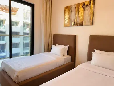 two beds in a room with a window at Exclusive Retreat and Spacious Unit in JVC in Dubai