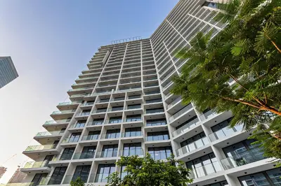 a tall building with windows and a palm tree at Modern Studio at Paragon with City View in Dubai