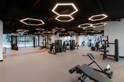 a gym with rows of exercise equipment and lights at Modern Studio at Paragon with City View in Dubai