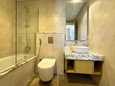 a bathroom with a toilet and a sink and a shower at Sleek Charm Inviting Atmosphere and Cozy Balcony in Dubai
