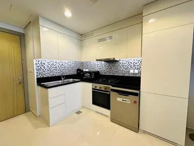 a kitchen with white cabinets and a stove top oven at Sleek Charm Inviting Atmosphere and Cozy Balcony in Dubai