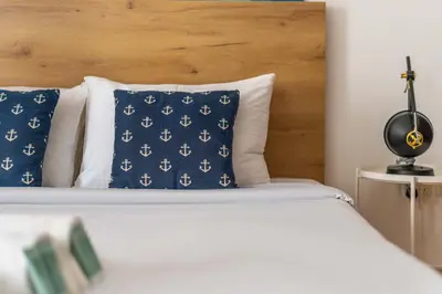 a bed with blue pillows and a wooden headboard at Spacious 2BR Flat with Gym & Pool in JBR in Dubai