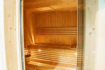 a sauna with wooden walls and a glass door at Modern Studio in Business Bay l Pool, Gym & Sauna in Dubai