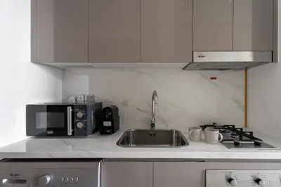 a kitchen with a sink and a microwave at GuestReady - Chic & modern studio in Dubai in Dubai