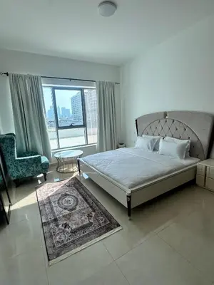 a bedroom with a bed and a chair and a window at Stay Inn AlBarsha by PHM in Sabkhah