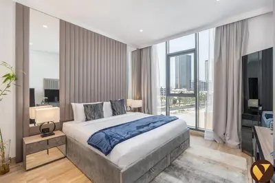 a bedroom with a bed and a large window at Vogue JVC Chaimaa Avenue near Circle Mall, One Bedroom Apartment with Balcony and City View, Access to all Amenities in Dubai