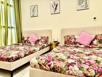 two beds in a room with pink pillows at Jaddaf NS Building in Dubai