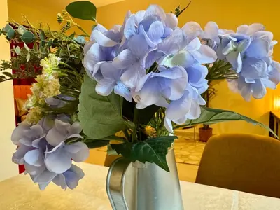 a vase filled with blue flowers on a table at Sandoval Gardens JVC in Dubai