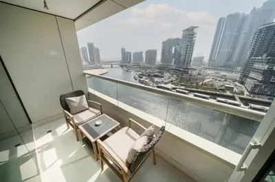 a balcony with a hammock and a table and chairs at Chic Business Bay 1Bed Retreat with Canal Views in Dubai