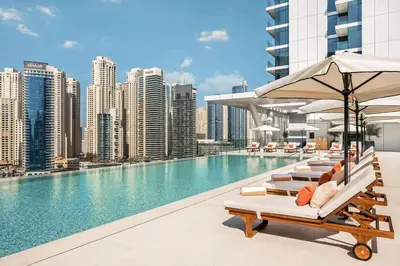 a pool with chairs and umbrellas on a building at Seraya Residences at Marina Yacht Club - Vida Marina in Dubai