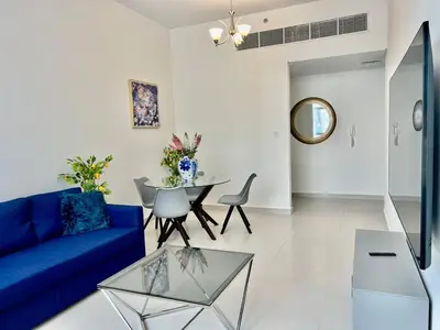 a living room with a blue couch and a table at Al Karama close to subway in Dubai
