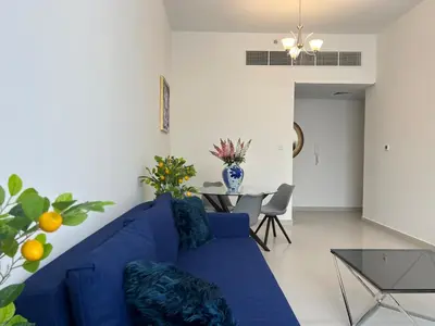 a blue couch in a living room with a table at Al Karama close to subway in Dubai