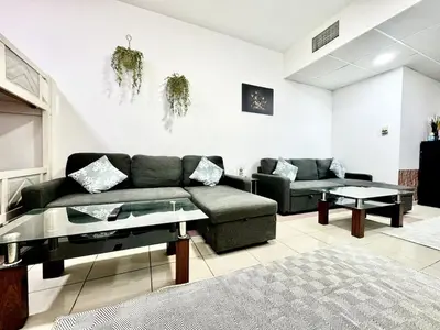 a living room with a couch and a table at Mina Road AL Thayer in Dubai