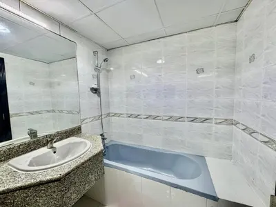a bathroom with a sink and a bath tub at Mina Road AL Thayer in Dubai