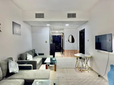 a living room with a couch and a table at Mina Road AL Thayer in Dubai