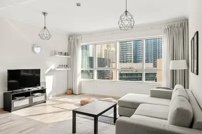a living room with a couch and a tv at Elegant 1-Bedroom Apartment in Dubai Marina in Dubai