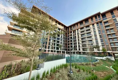 a large building with a swimming pool in front of it at Central Park Building, City Walk - 1BR Sophisticated Apartment in Dubai