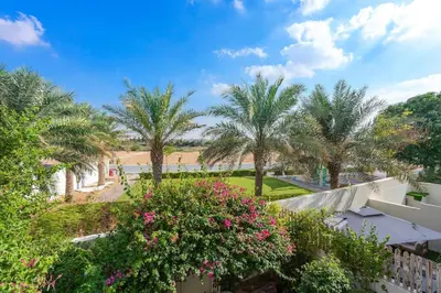 a view of a garden with palm trees and flowers at Elegant 3BR Villa with Access to Pool & Gym in Dubai