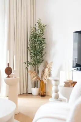 a living room with plants in vases on the floor at Modern 1BR Steps from Burj AlArab Madinat Jumeirah By AYA Boutique in Dubai
