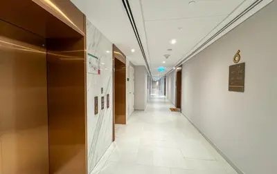a corridor of an office building with a long hallway at Modern 1BR Steps from Burj AlArab Madinat Jumeirah By AYA Boutique in Dubai