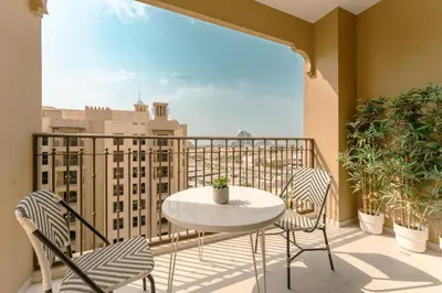 a balcony with a table and chairs and a view of a city at Modern 1BR Steps from Burj AlArab Madinat Jumeirah By AYA Boutique in Dubai