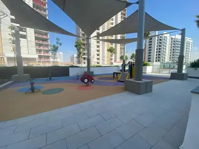 a playground in a city with tall buildings at Charming Studio with Pool, Gym, Kid's playground in Dubai