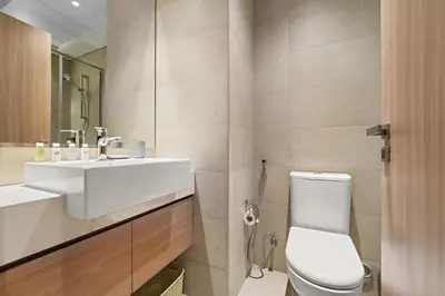 a bathroom with a white toilet and a sink at Charming Studio with Pool, Gym, Kid's playground in Dubai