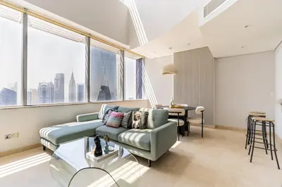 a living room with a couch and large windows at Chic Urban Loft SkyGardens DIFC, Dubai in Dubai