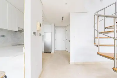 a kitchen with white walls and a white refrigerator at Chic Urban Loft SkyGardens DIFC, Dubai in Dubai