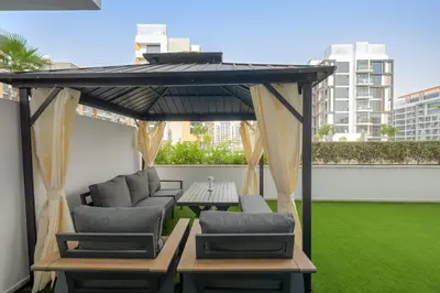 a gazebo with chairs and a table on a balcony at VayK - Modern 1BR with Spacious Terrace in Dubai