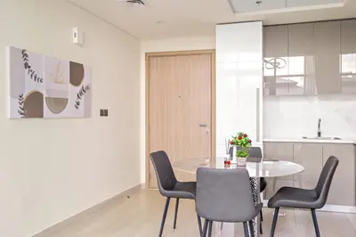 a kitchen and dining room with a table and chairs at VayK - Modern 1BR with Spacious Terrace in Dubai