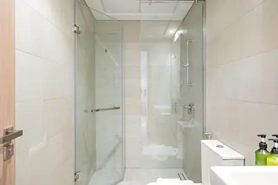 a bathroom with a shower and a toilet and a sink at VayK - Modern 1BR with Spacious Terrace in Dubai